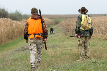 Hunting period, autumn season open. A hunter with a gun in his hands in hunting clothes in the...