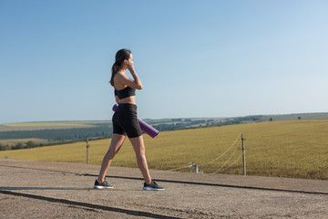 A young slim athletic girl in sportswear with snakeskin prints performs a set of exercises. Fitness and healthy lifestyle.	