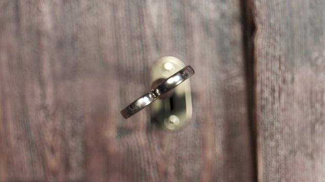 Animation of opening an older golden door lock. Close-up view at a key. 4KHD
