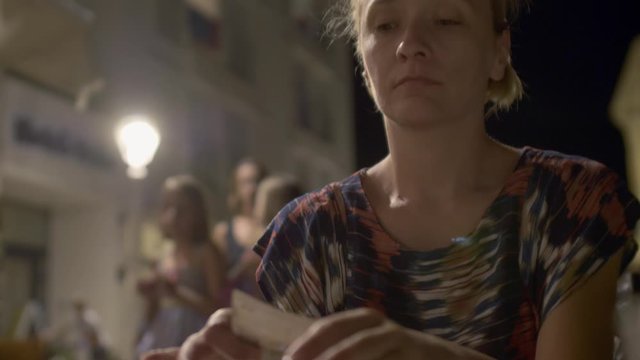 Woman paying the bill at dinner after eating pizza. Money are being placed in a small folder with a text "Bill" on it.