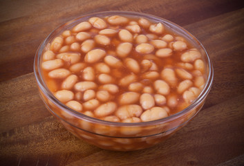 Baked beans in tomato sauce on wooden background