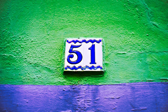 Number 51, fifty-one, old decorative tiles on green and blue background.