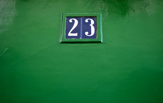 Number 23, twenty-three, blue tiles on green background.
