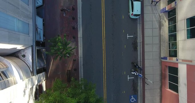 Aerial drone shot of bus and skateboarder going down empty street in downtown Durham.