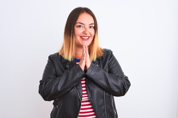 Young beautiful woman wearing striped shirt and jacket over isolated white background praying with hands together asking for forgiveness smiling confident.