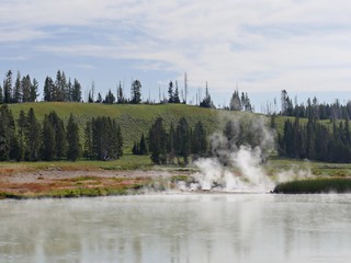 Medium close up of steam rising from a hot spring at the Yellowstone River at Yellowstone National Park.