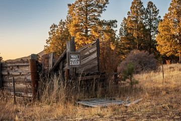 Fototapeta na wymiar Abandoned cattle ramp during sunset in the fall with no tresspassing sign