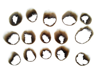 Collection of burnt holes in a piece of paper isolated on white background. Fire holes in white paper.