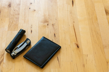 over head shot of male pocket contents flat lay with knife, flash light, and wallet