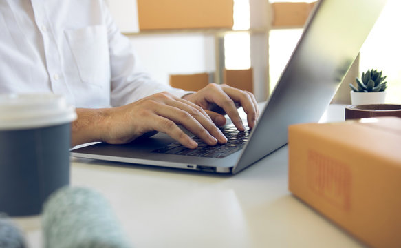 Entrepreneurs are working on taking orders of customers products by typing information tpying keyboard laptop computer in office room.