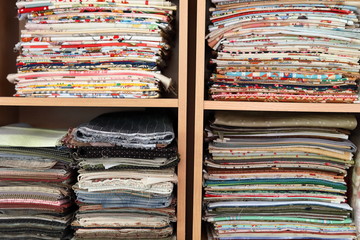 stack of pieces fabric many pattern on shelf, material recycle for clothing fashion design
