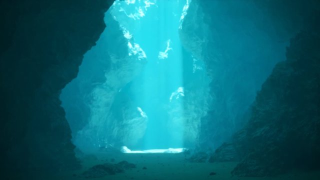 Underwater cave illuminated by sunbeams pouring through a surface opening. 4KHD