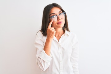 Young beautiful businesswoman wearing glasses standing over isolated white background Pointing to the eye watching you gesture, suspicious expression