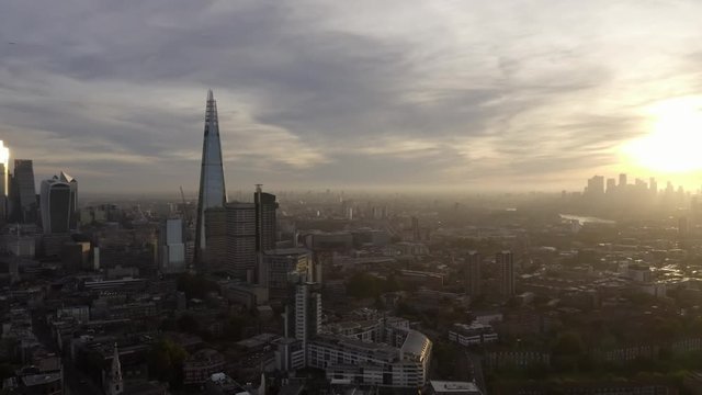 Video shows London's sunrise landscape. The sun ray shines through the skyscrapers and brighten the city on a foggy morning.