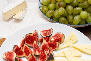 Green grapes, fresh figs and white cheese on the table