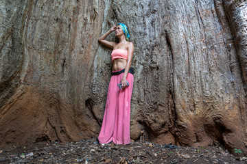 A beautiful girl is standing inside the trunk of an old baobab tree on the island of Zanzibar,...