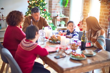 Beautiful family smiling happy and confident. Eating roasted turkey celebrating christmas at home