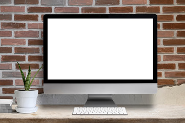 Fototapeta premium Mockup desktop computer white blank screen, houseplant and book on wooden table, blank screen for graphic design.