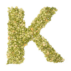 Letter K of the English alphabet from  freshly  green chopped peas  on a white isolated background. Food pattern made from peas. bright alphabet for shops. pea cereal