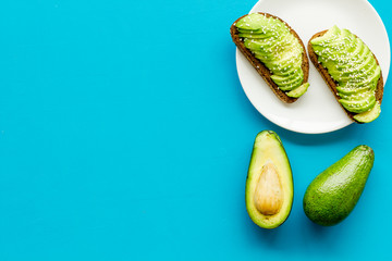 Healthy food. Avocado toast on blue background top view frame copy space
