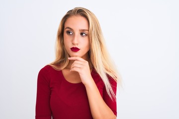 Young beautiful woman wearing red t-shirt standing over isolated white background serious face thinking about question, very confused idea