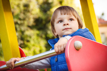Fototapeta na wymiar Little child playing on playground in park. Child development concept