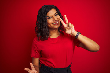 Naklejka premium Beautiful transsexual transgender woman wearing t-shirt over isolated red background smiling looking to the camera showing fingers doing victory sign. Number two.