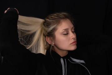 Mujer joven rubia en fondo negro  