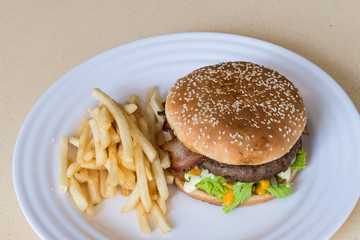 Jumbo beef burger with bacon, cheese, lettuce, tomato and french fries