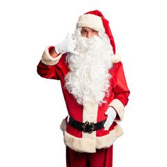 Middle age handsome man wearing Santa Claus costume and beard standing smiling doing phone gesture with hand and fingers like talking on the telephone. Communicating concepts.