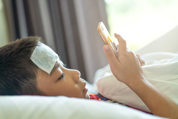 Obraz na płótnie Canvas the boy using cooling gel sheet on head for medical he fever
