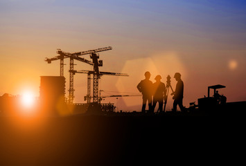 Silhouette of Survey Engineer and construction team working at site over blurred  industry...