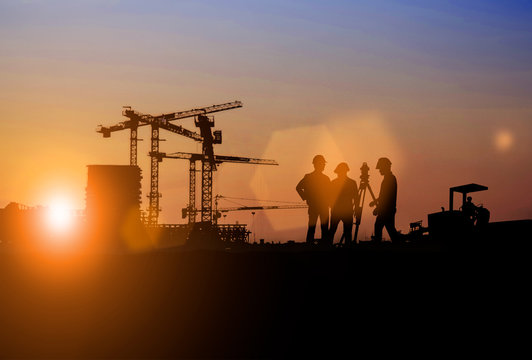 Silhouette of Survey Engineer and construction team working at site over blurred  industry background with Light fair Film Grain effect.Create from multiple reference images together
