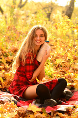 Outdoor fashion photo of young beautiful lady surrounded autumn leaves