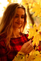 Outdoor fashion photo of young beautiful lady surrounded autumn leaves