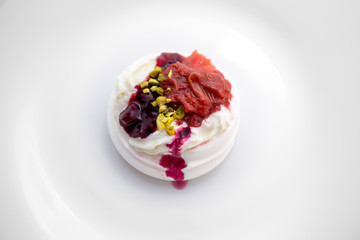 Dessert Pavlova of meringue with rhubarb and pistachio