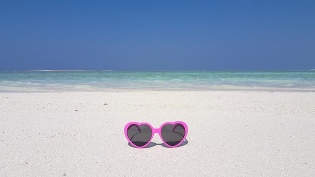 Pink Sunglasses on the Seashore With Turquoise Sea and Clear Blue Sky in Australia - Close Up Shot