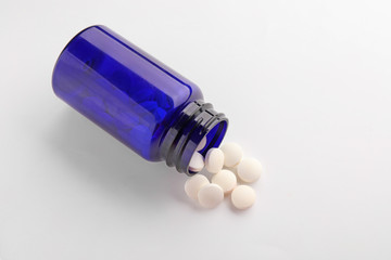 Bottle with pills on white background