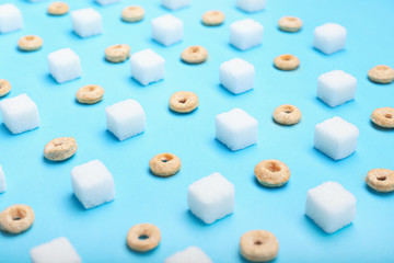 Sugar cubes and dry breakfast on color background