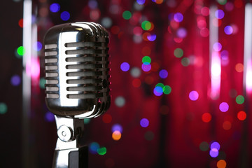 Fototapeta na wymiar Retro microphone on stage against defocused lights