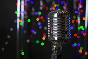 Fototapeta na wymiar Retro microphone on stage against defocused lights
