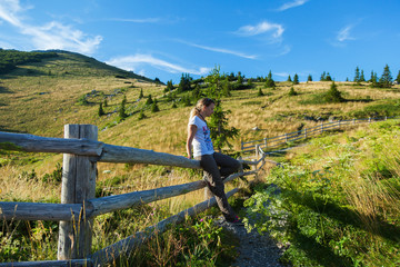 Girl on the fence in the mountain