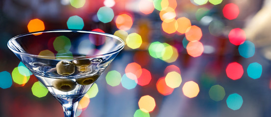concept of a bachelorette party and birthday celebrations. Dirty martini cocktail on a multicolored bokeh background.