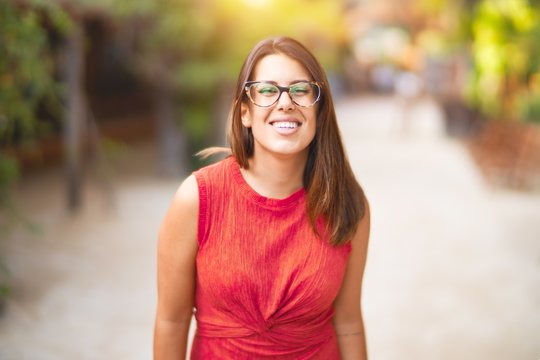 Young beautiful girl smiling happy and confident walking at the town park, standing with a smile on face