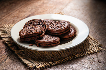 Chocolate sandwich cookie wafers on white plate.