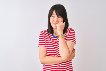 Young beautiful chinese woman wearing red striped t-shirt over isolated white background looking stressed and nervous with hands on mouth biting nails. Anxiety problem.