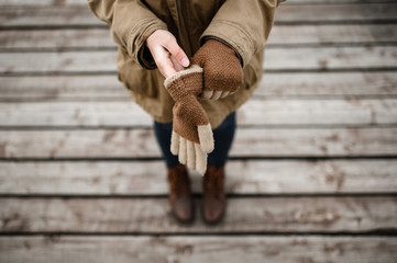 girl puts on her hands warm winter wool gloves