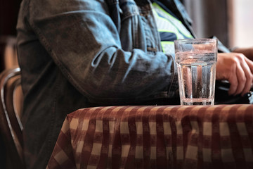 One glass of water placed on a table. Focus on glass.