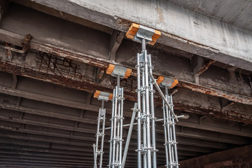 Heavy-duty pylons support a destroyed bridge beam.