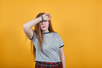 Displeased puzzled young woman in gray casual clothes point fingers to head like sick isolated on bright yellow orange background. People lifestyle concept. Mock up copy space